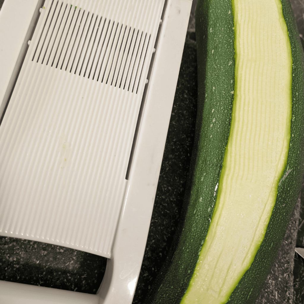 Close-up of a fresh zucchini on a kitchen counter.