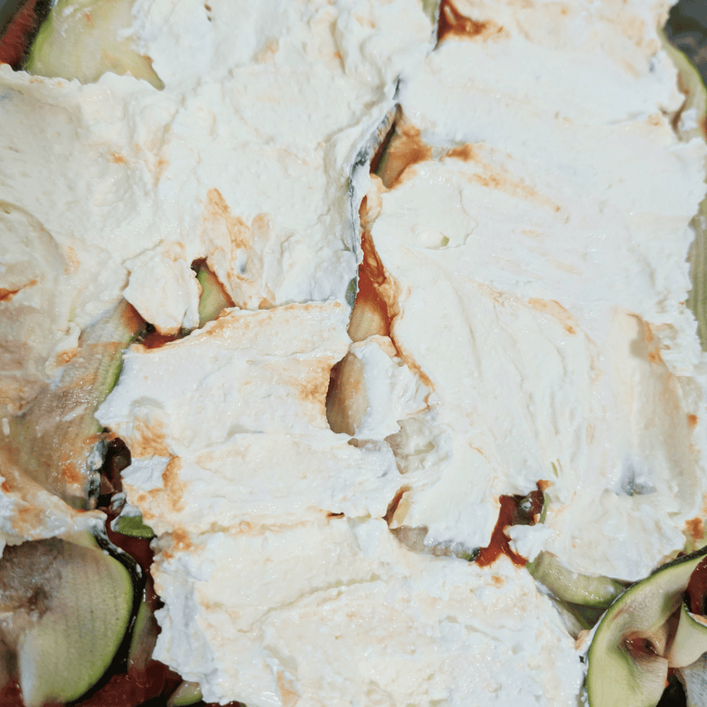 Close-up of a creamy vegetable salad with herbs and cheese.
