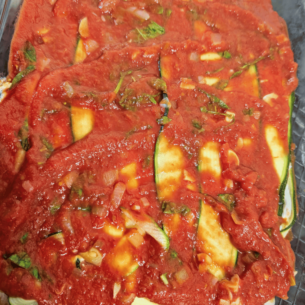 Zucchini slices topped with homemade tomato sauce and herbs.