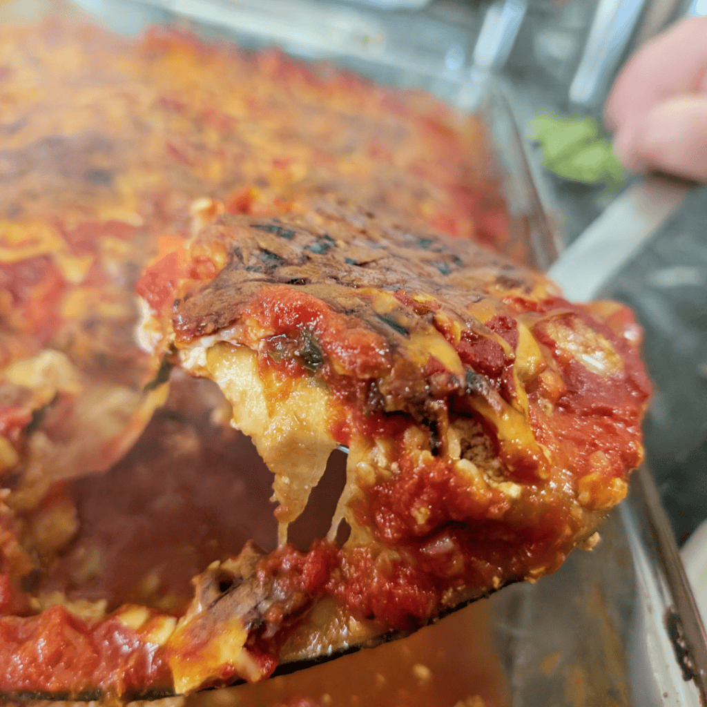 Close-up of a slice of homemade eggplant Parmesan with melted cheese and tomato sauce.