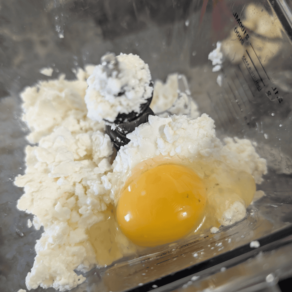 Cottage cheese with an egg in a blender for zucchini lasagna.