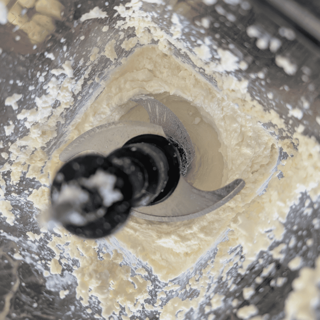 Creamy cottage cheese mixture in food processor for zucchini lasagna.