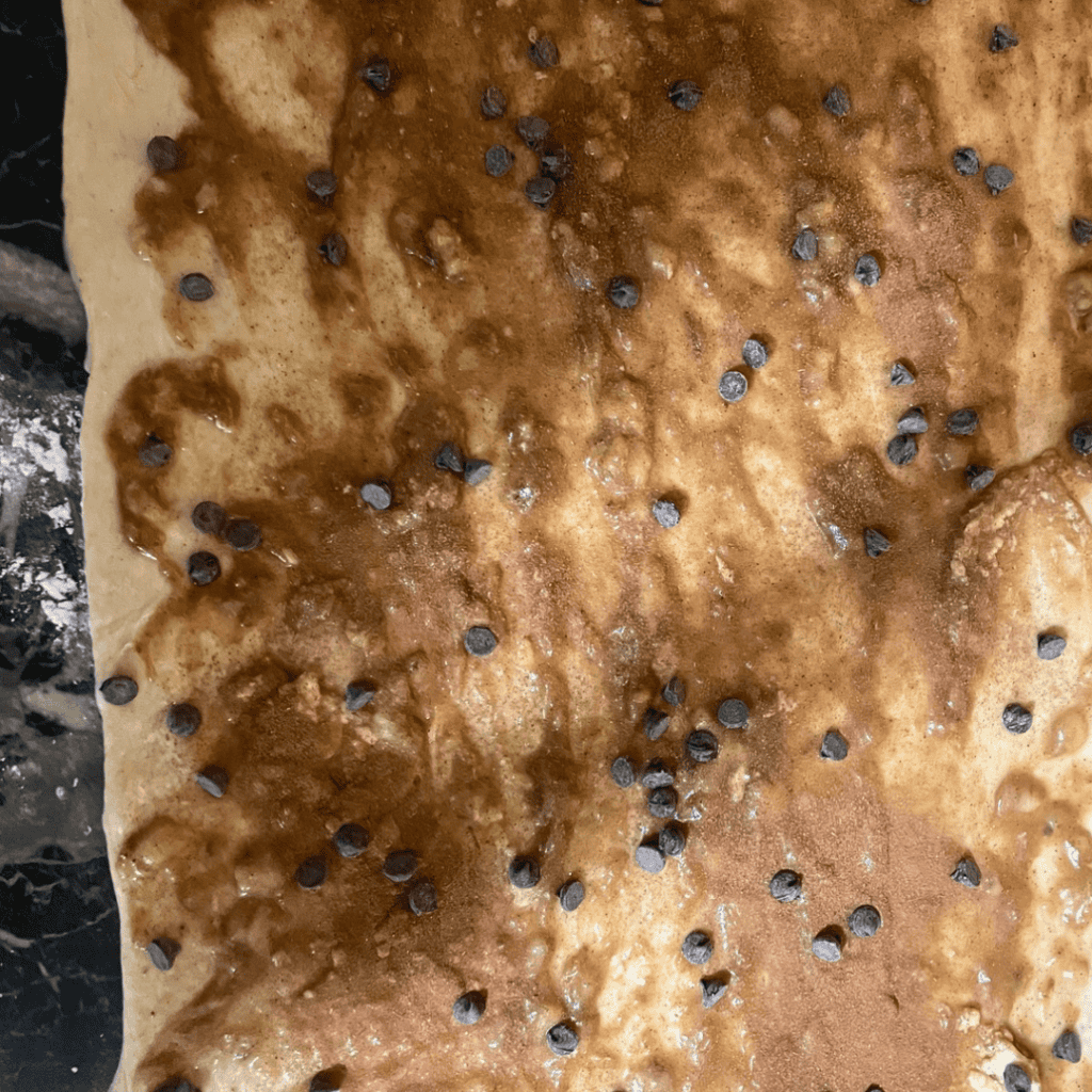 Close-up of banana bread cinnamon rolls topped with chocolate chips.