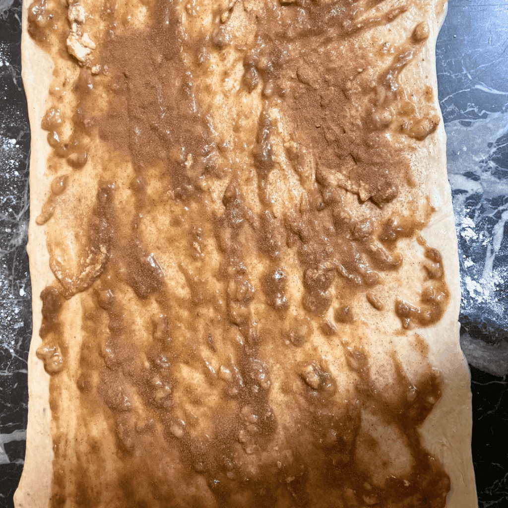 Unbaked banana bread cinnamon rolls with chocolate chips on parchment paper.