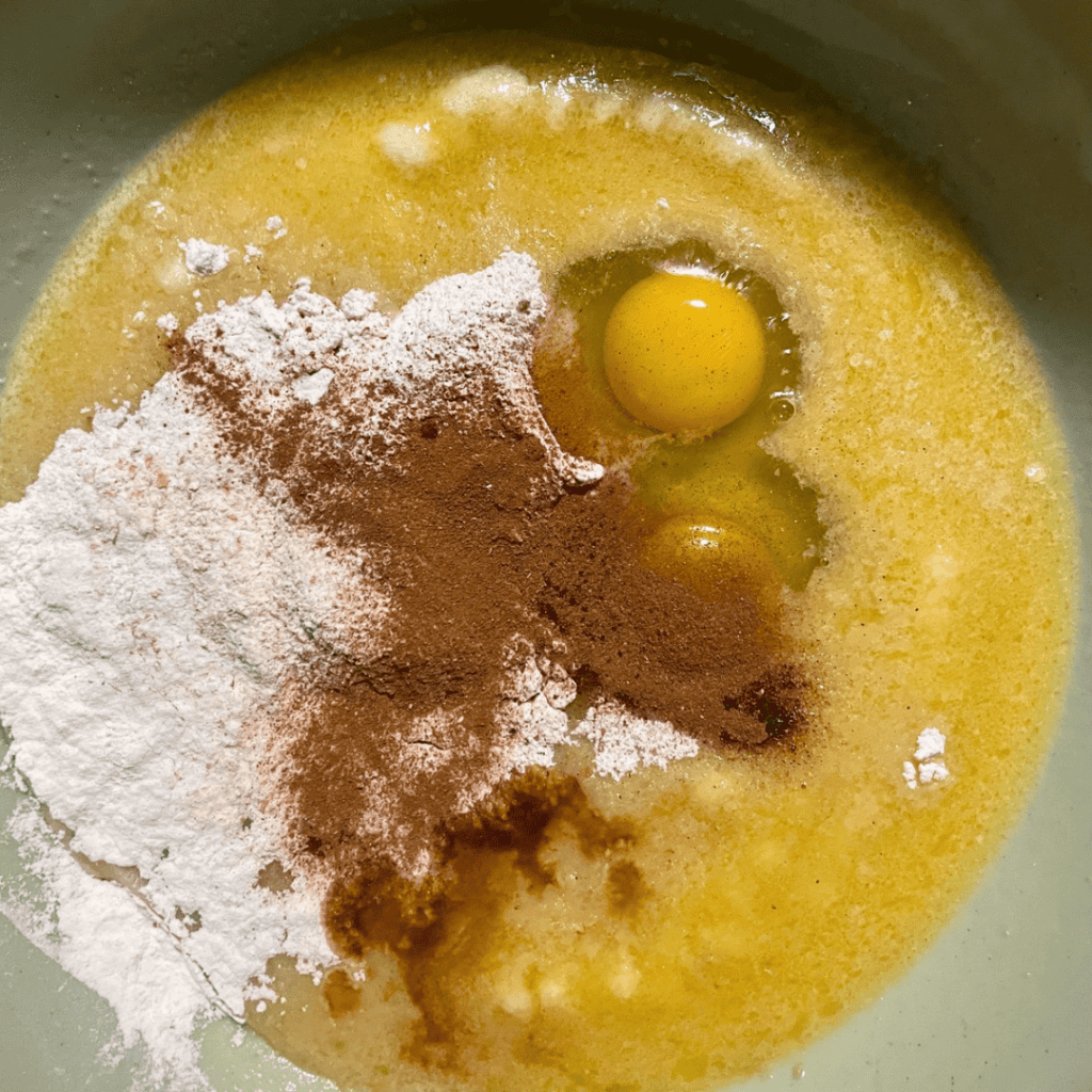 Mixing eggs, flour, cinnamon, and sugar for banana bread cinnamon rolls.