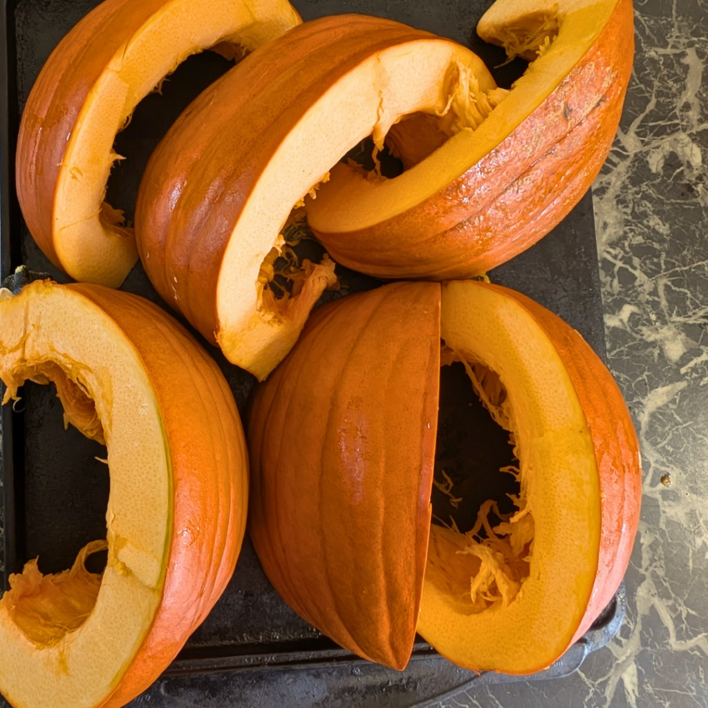 uncooked pumpkin wedges on baking tray