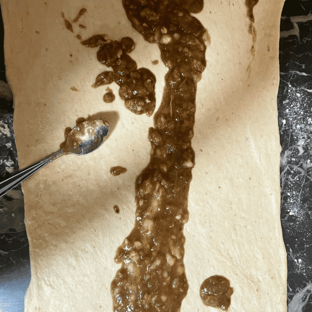 Banana bread cinnamon roll with chocolate chips on parchment paper.