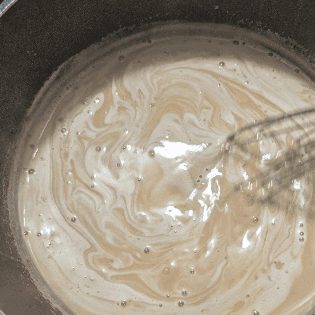 stirring with a whisk the mayonnaise base as it heats up in saucepan