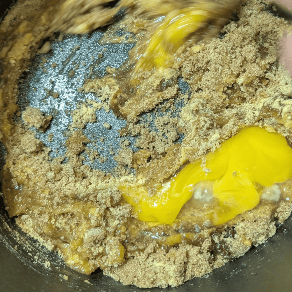 adding egg to the brown sugar mayonnaise base in a saucepan
