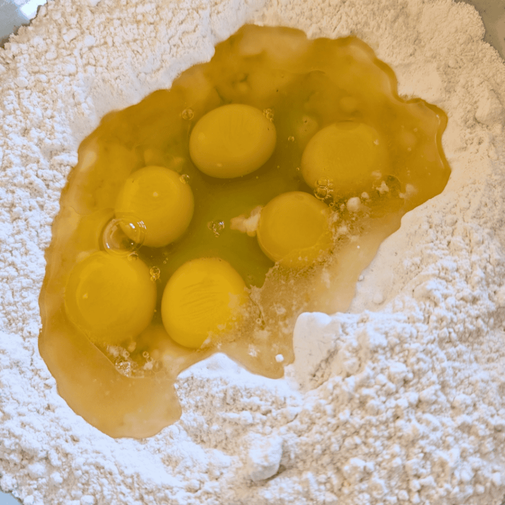 adding eggs to dry ingredients for popovers in bowl