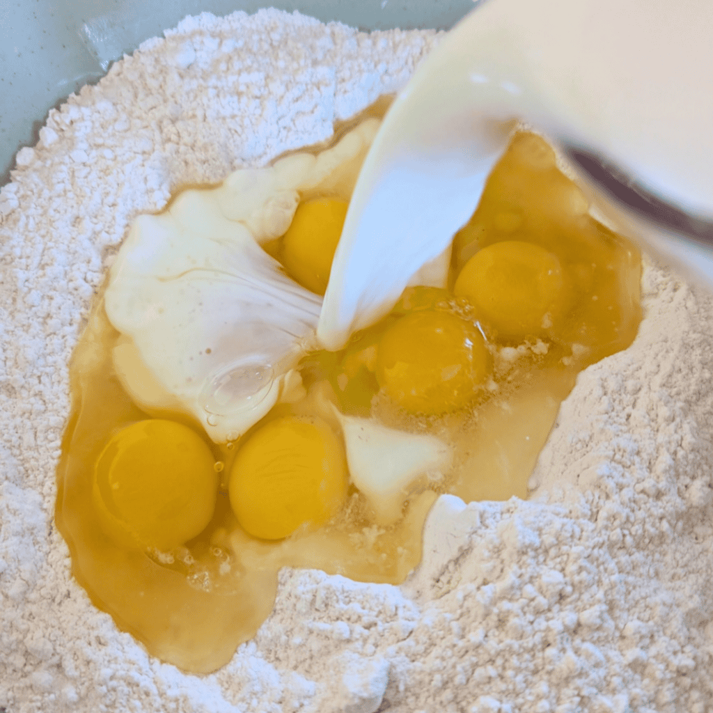 adding milk to dry ingredients for popovers in bowl