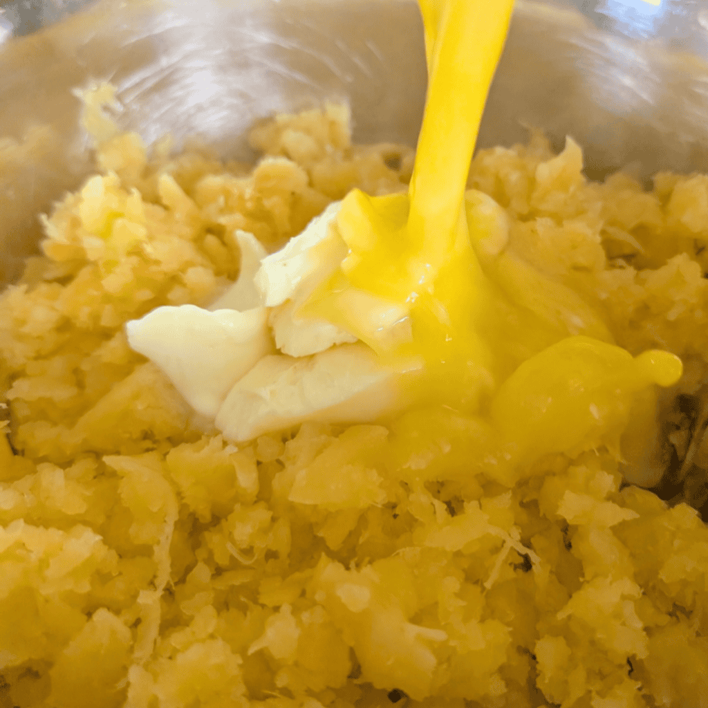 Mixing mashed rutabaga and butter for turnip puff recipe.