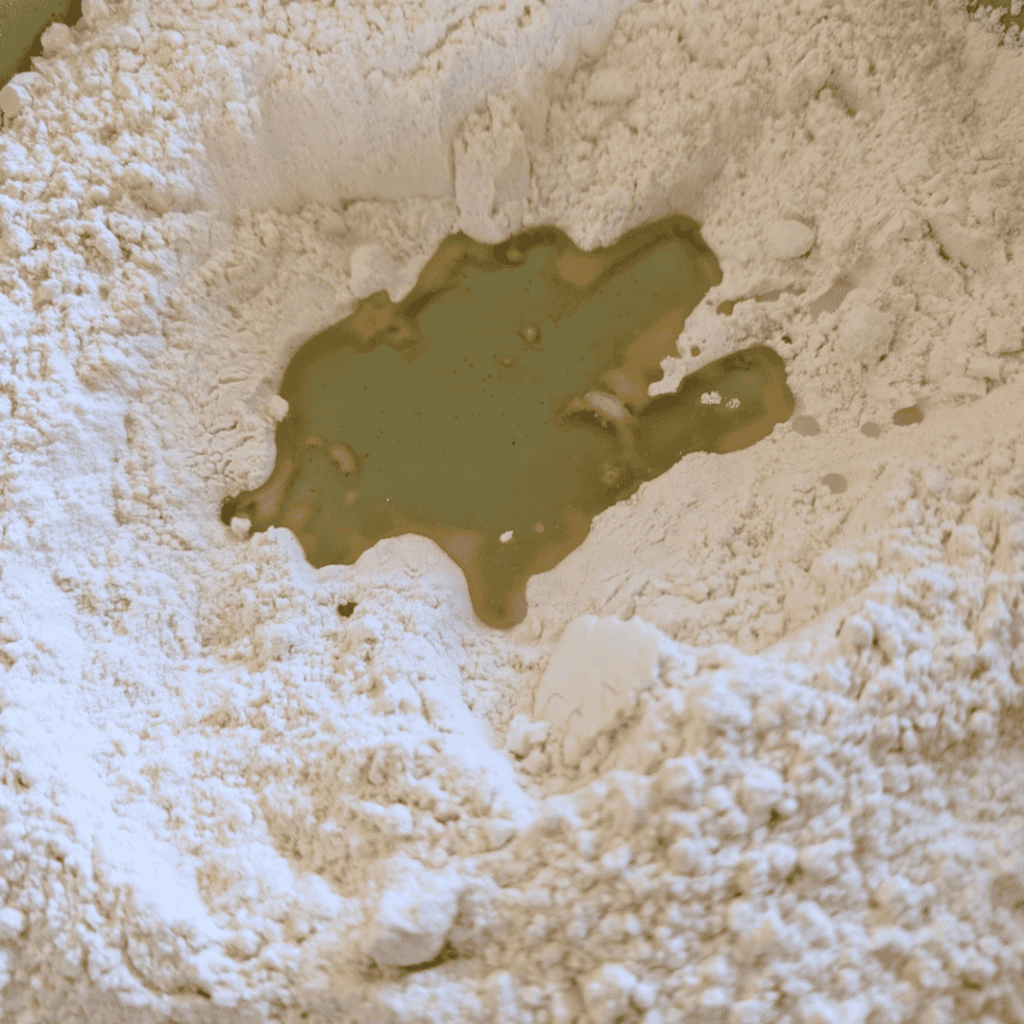 adding oil to dry ingredients for popovers in bowl