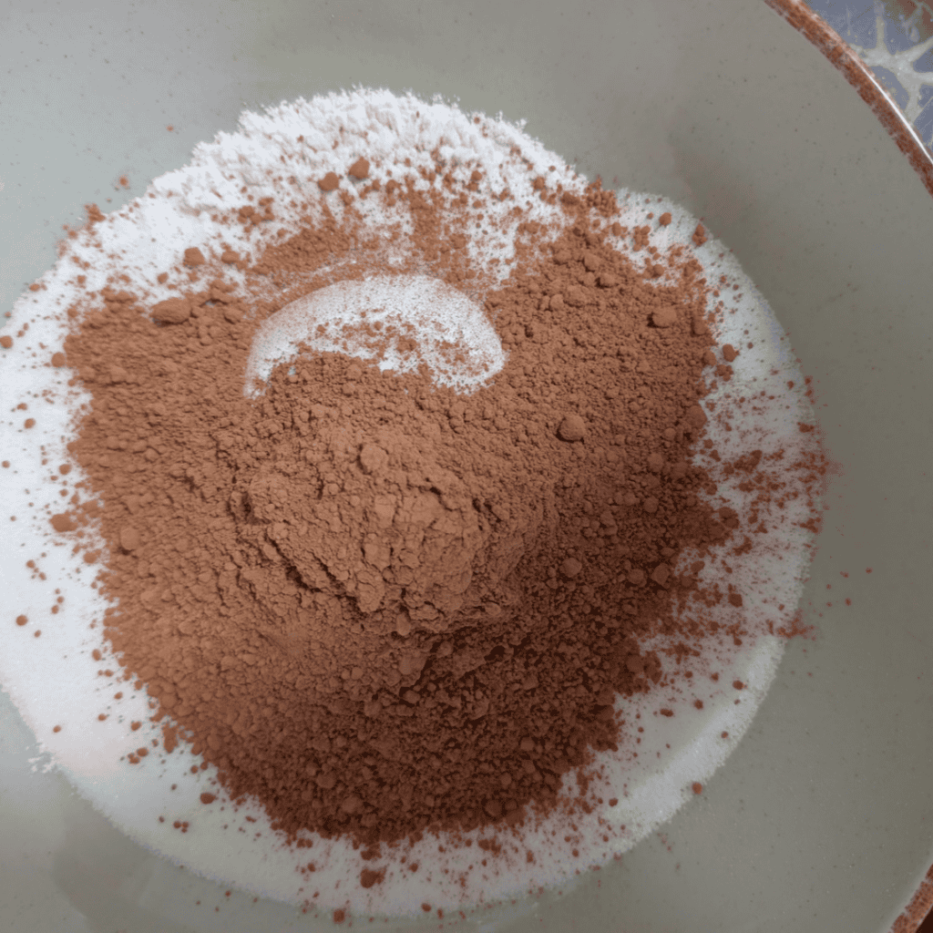 adding the cocoa to flour in bowl