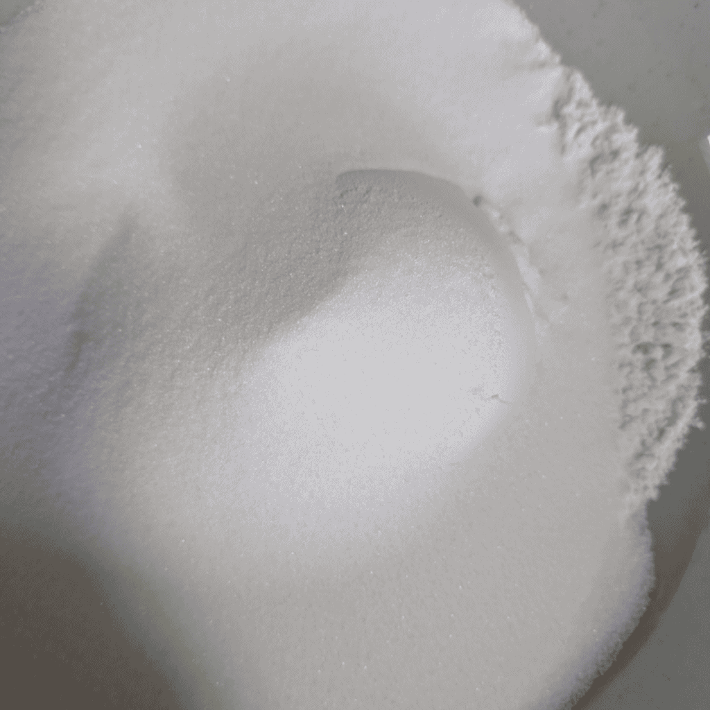 adding the sugar to flour in bowl