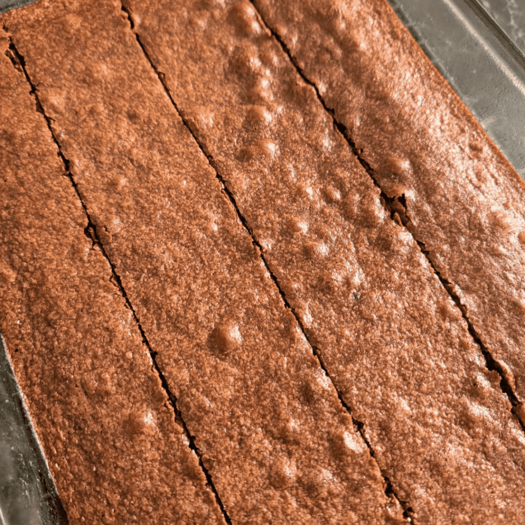 cutting cooled brownies with cocoa powder