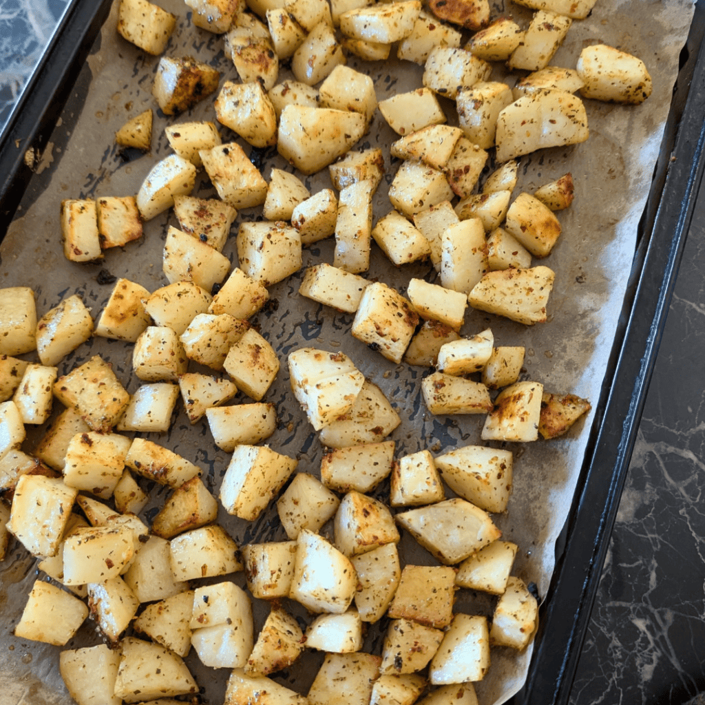 roasted cubed potatoes on baking sheet with parchment