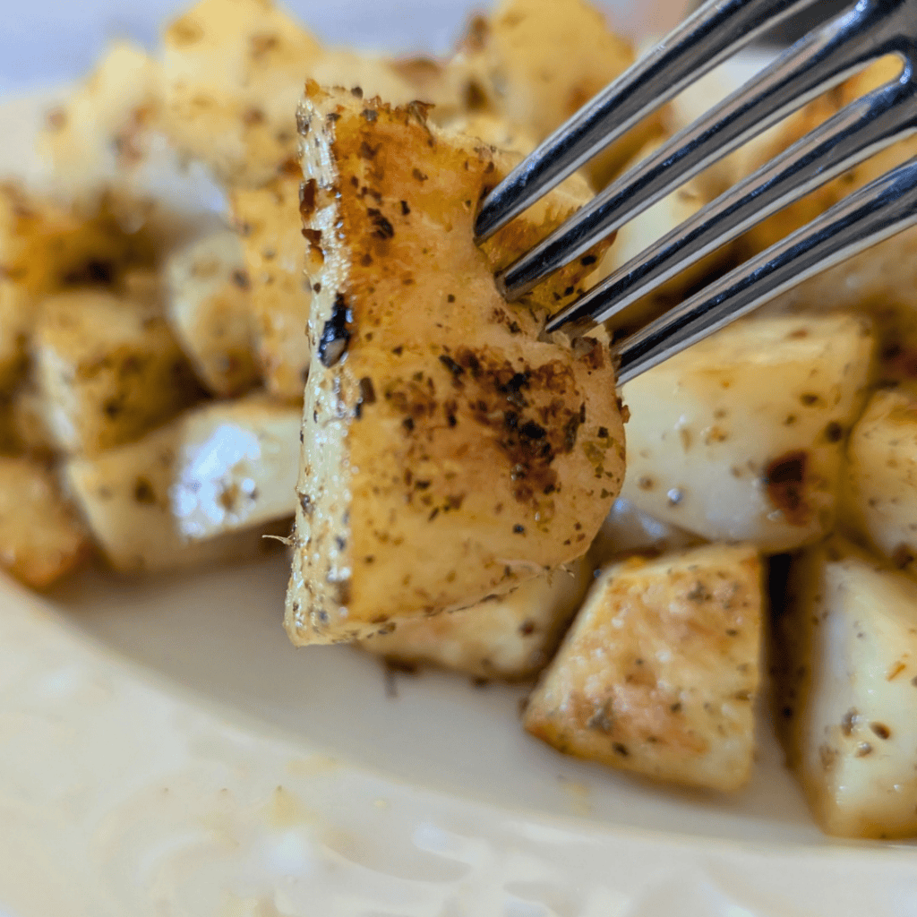 roasted cubed potatoe close up on fork tine