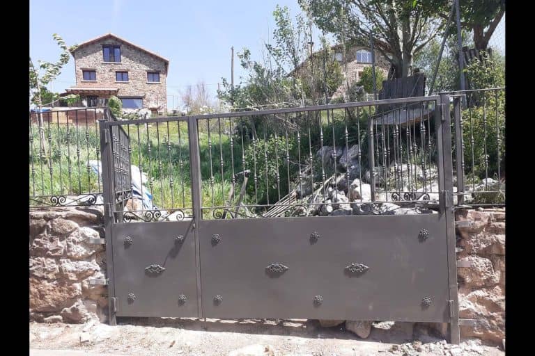 Puerta de hierro forjado resistente para entrada de casa en interior.