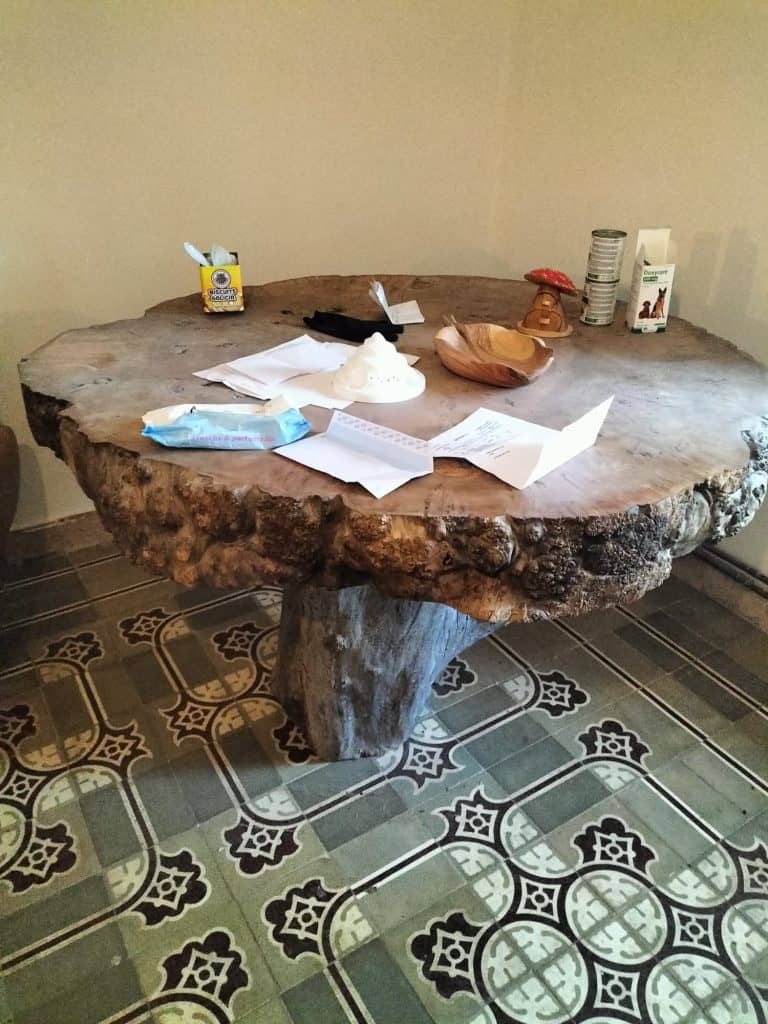Mesa de madera robusta en interior con objetos cotidianos y decorativos.