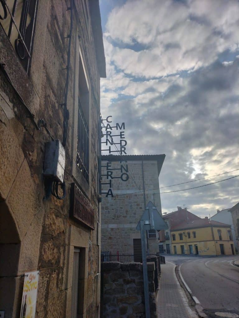 Puerta de euskera antigua en la calle con señalización de cerrajería.