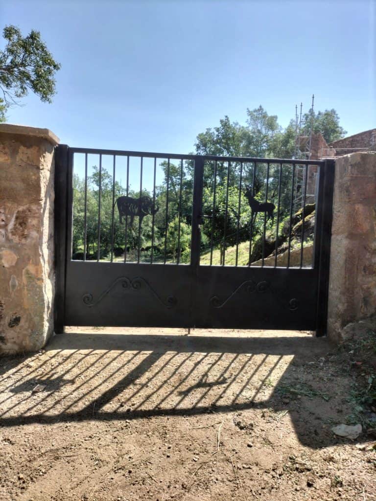 Puerta de hierro decorativa con diseño de animales, servicio especializado en cerrajería.
