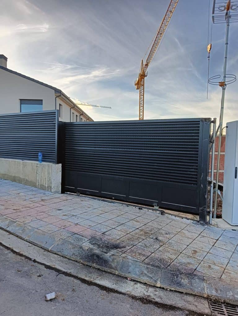 Puerta de garaje automatizada de metal negro, instalada por Cerrajería Osfran, expertos en cerraduras y puertas automáticas.