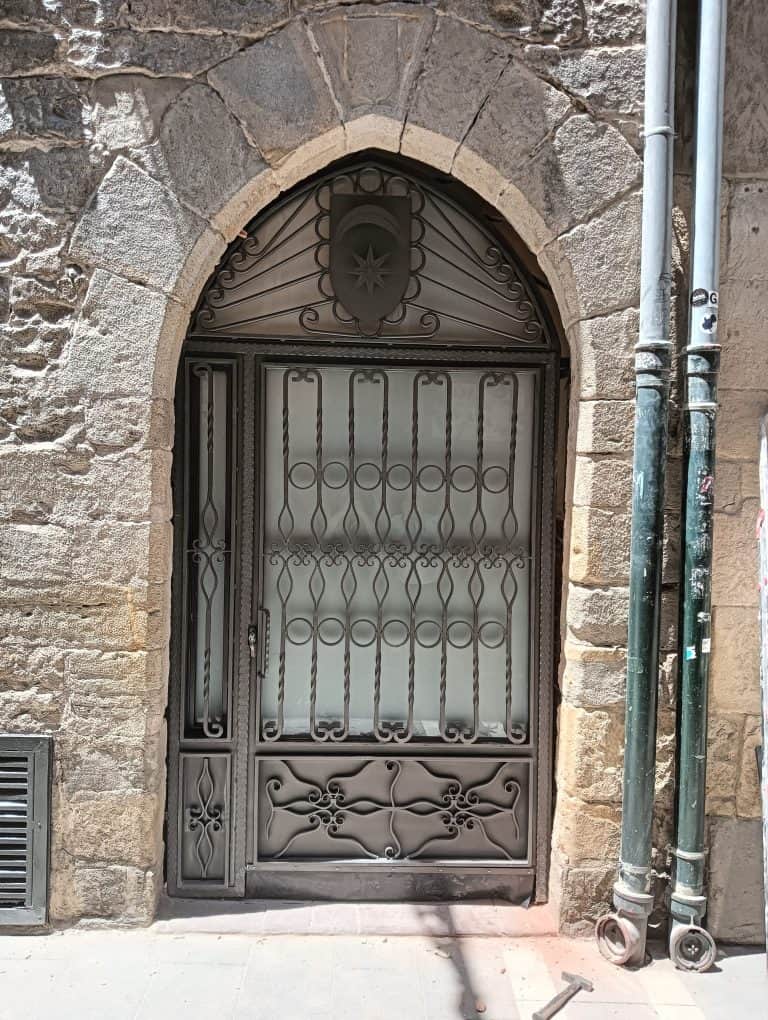 Puerta de hierro con diseño decorativo, seguridad y estilo para hogares históricos.