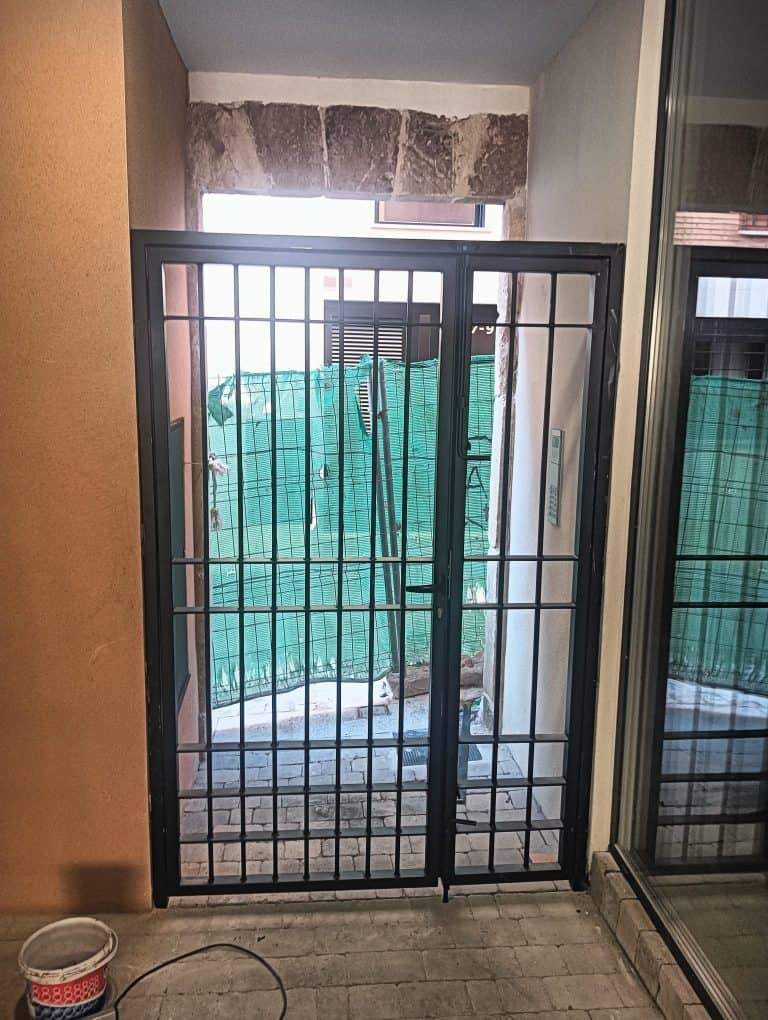 Puerta de reja de seguridad para protección en viviendas y negocios, instalación profesional.