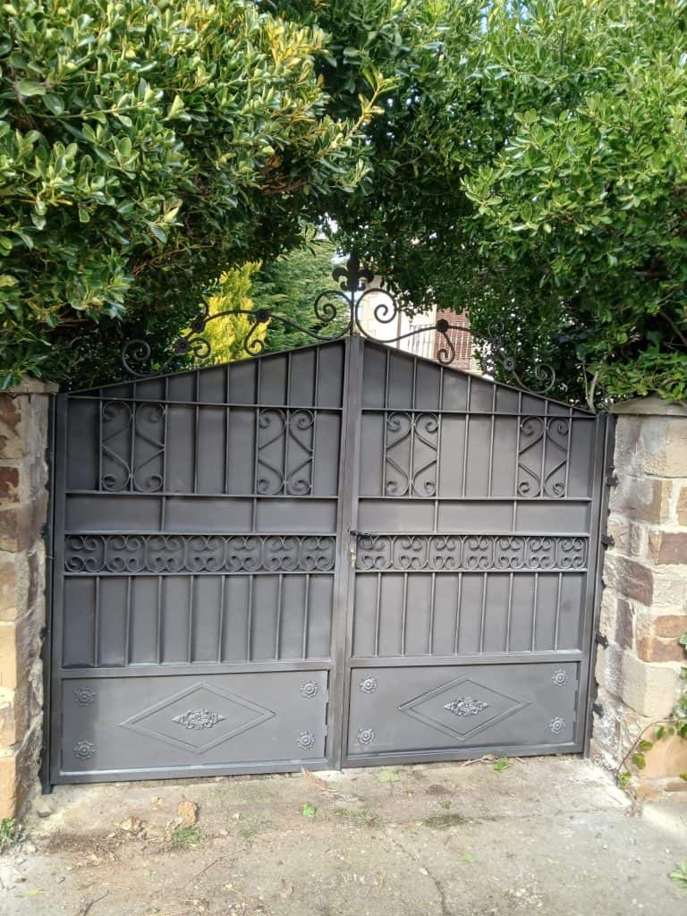 Puerta de hierro forjado con diseño ornamental para residencias.