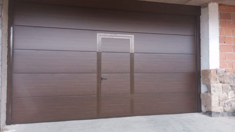Puerta de garaje de aluminio con puerta peatonal integrada.