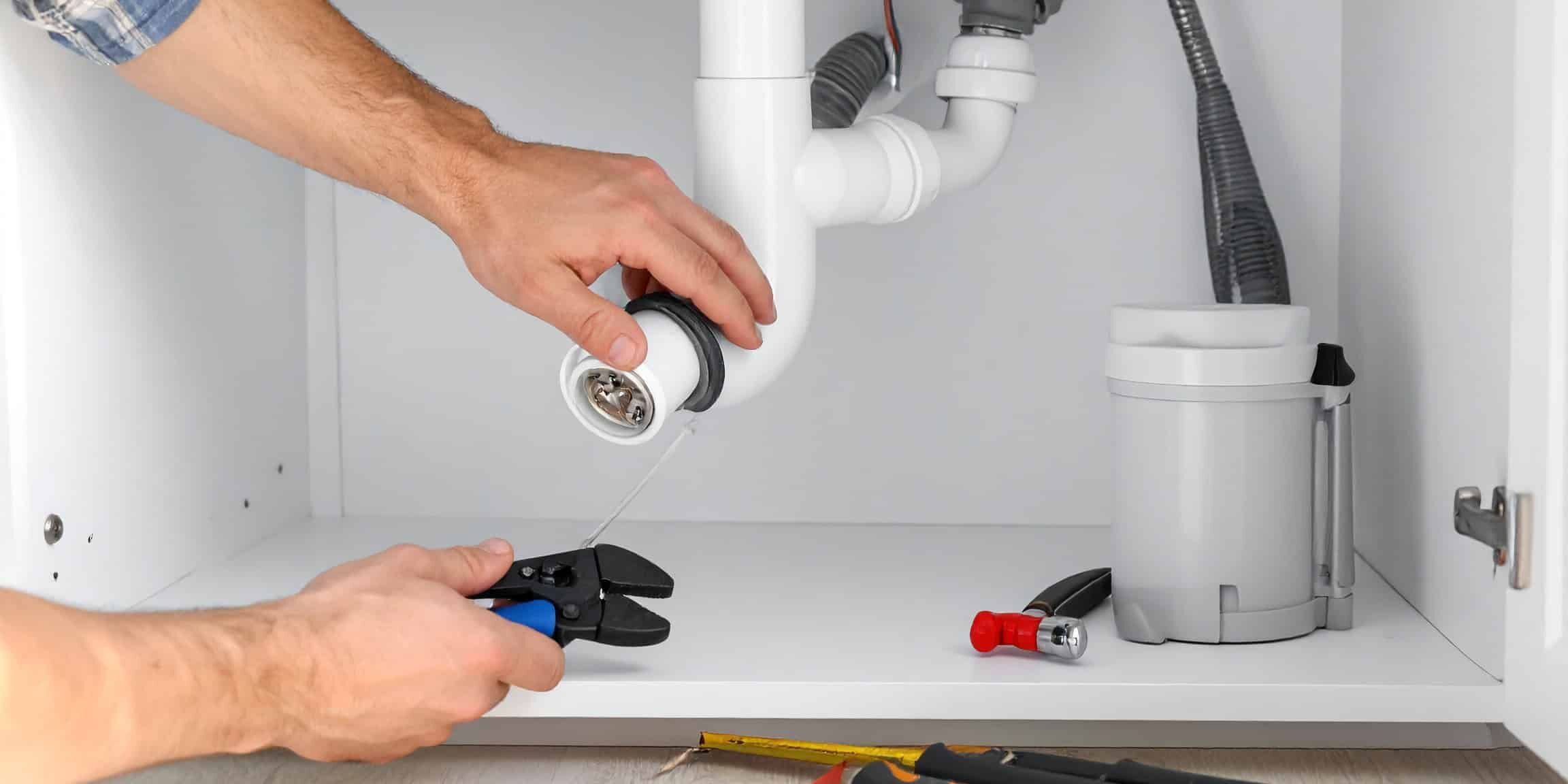 Firefly_Close-up of hands working under a residential kitchen sink, repairing drain pipes and 209041 (1)