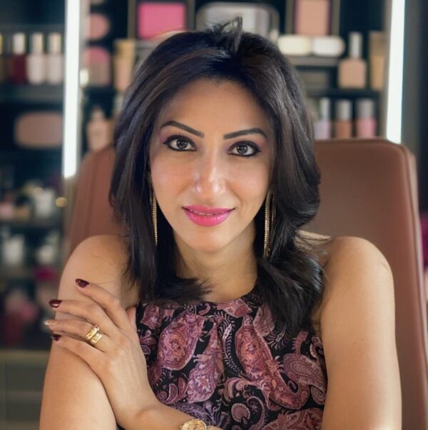 Woman with flawless makeup and dark hair in a beauty salon setting.