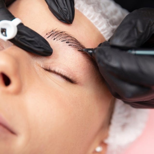 Microblading hair strokes being drawn on a client's eyebrow at Cleopatra PMU in Chantilly, Virginia
