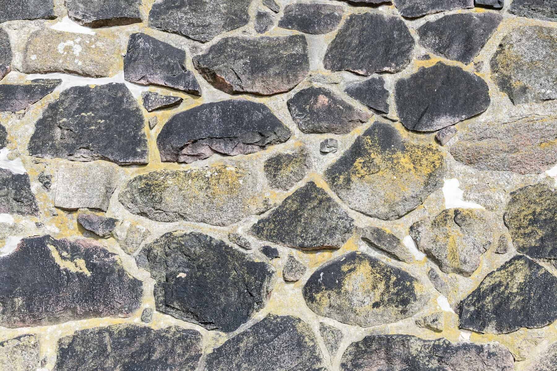 Mortared New England fieldstone wall, the granite and cobble masonry common on Cape Cod homes in Falmouth, MA