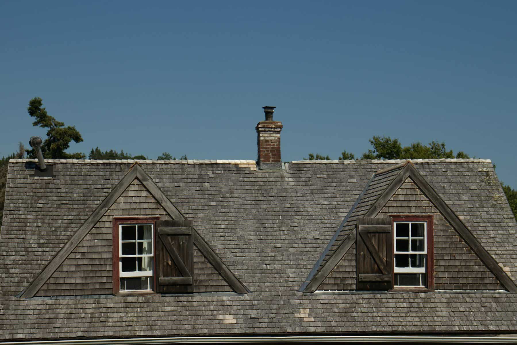 Dormers on a Cape Cod roof in Sandwich, the kind of roof where low slope sections meet the main pitch