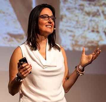 Sonja Piontek speaking on stage in a white top