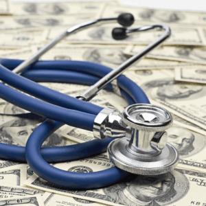 Stethoscope on a pile of money, symbolizing Medicaid planning and the financial impact of the new Medicaid transfer penalty divisor.