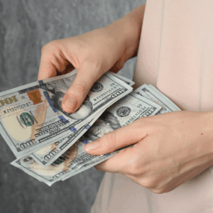 Hands counting $100 bills, illustrating the 2026 Maximum Protected Resource Limit for the Community Spouse under Texas Medicaid rules.