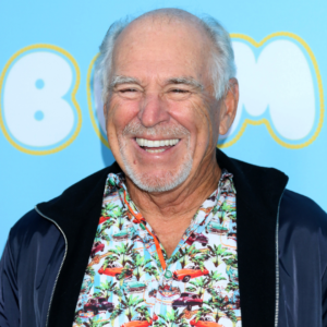Jimmy Buffett smiling in a tropical-print shirt