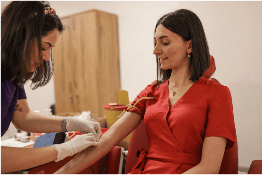 Nurse supporting a seated patient during a medical appointment