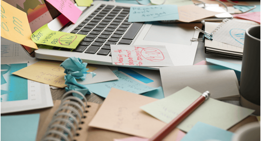 Desk with scattered papers and a laptop