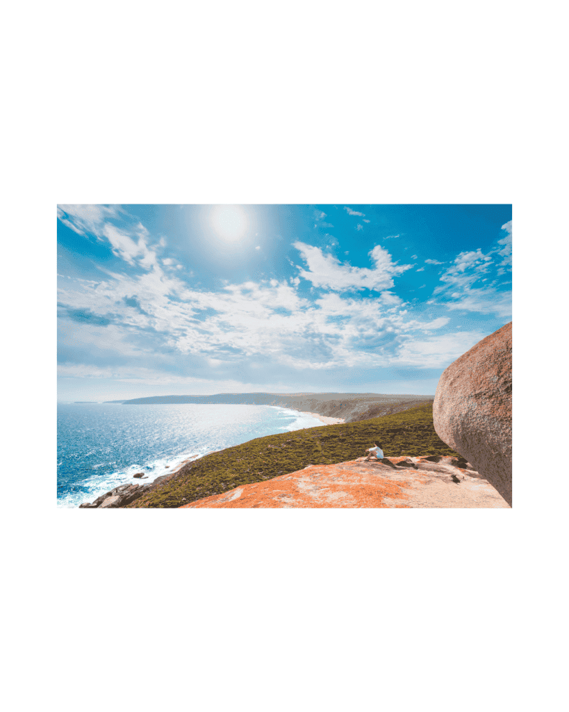 A person sitting peacefully on a cliff overlooking the ocean, embracing the height with confidence.