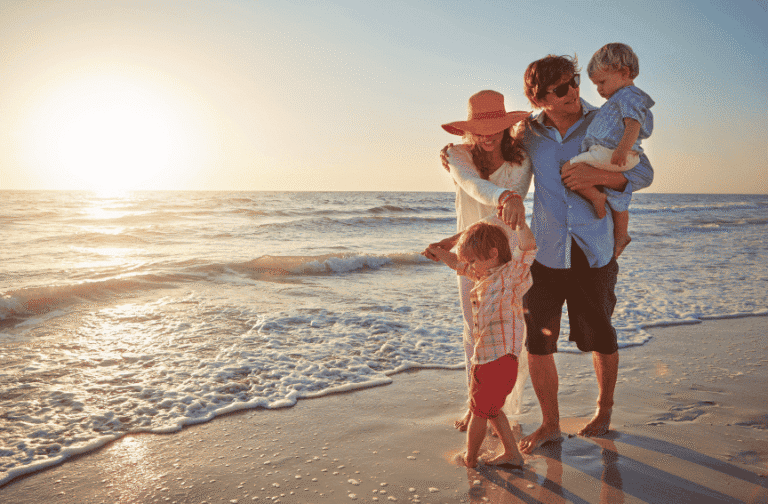 Family walking by the ocean at sunset, representing peace, freedom, and clarity after drug recovery.