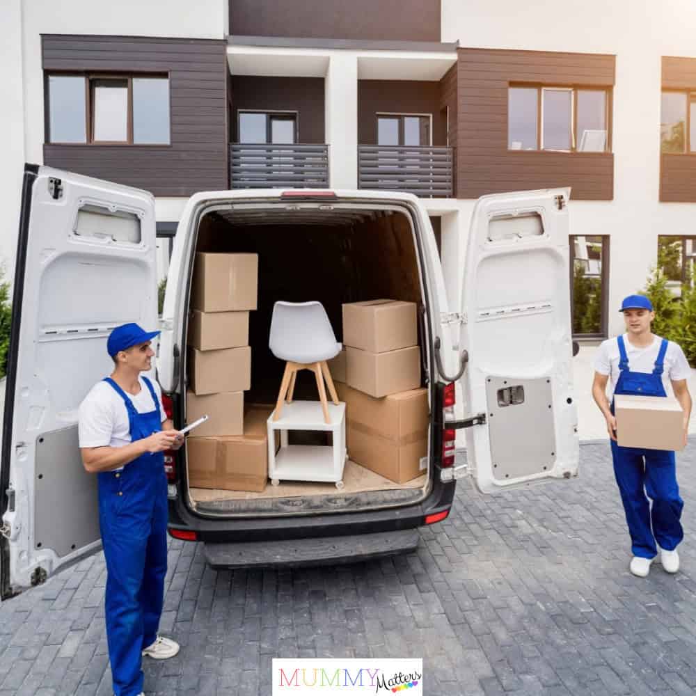 Two removal workers loading boxes into a van during a house move