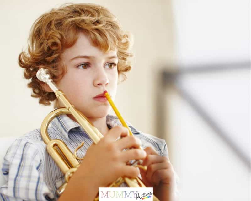 Boy learning to play a trumpet