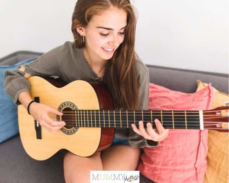Teenage girl playing a guitar