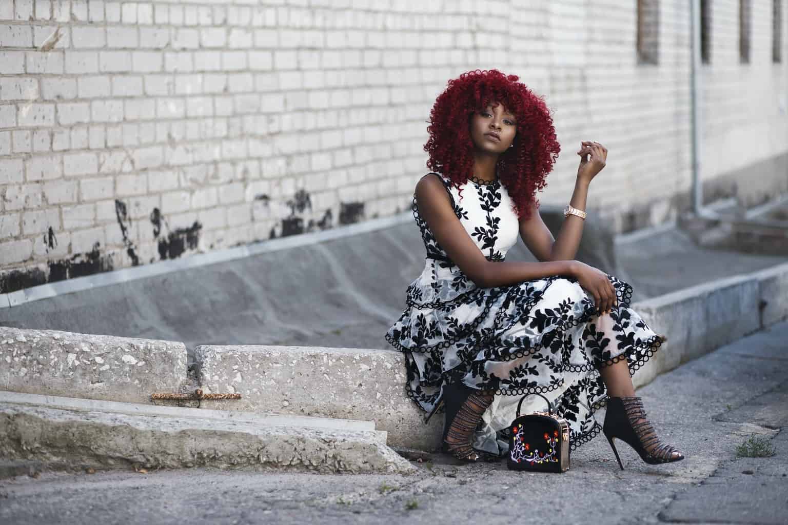 red haired woman in white and black floral sleeveless maxi dress