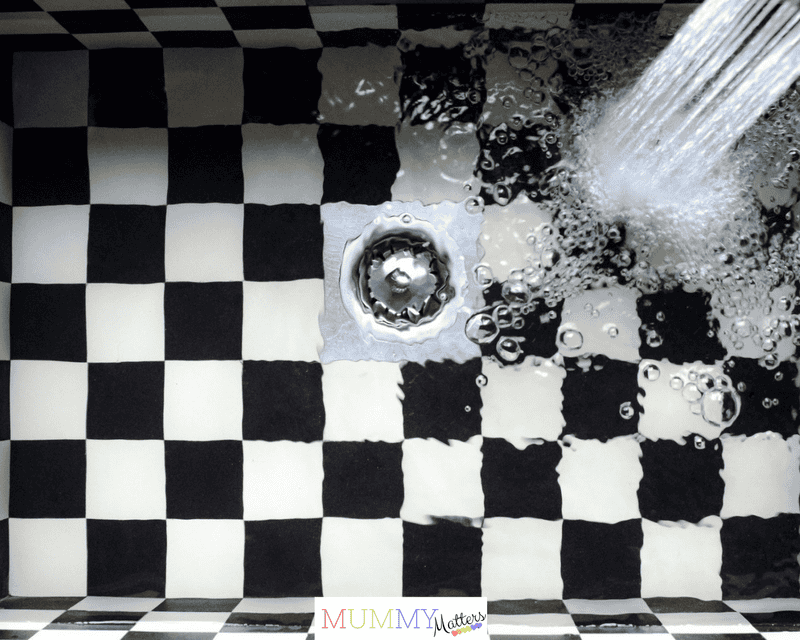 Top view of a checkered sink with water splashing, showcasing elegant design.