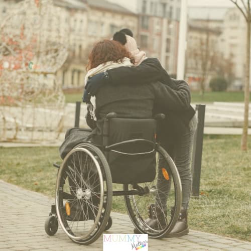 Woman in wheelchair being consoled